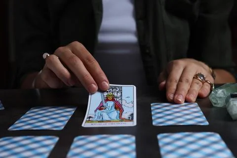 Fortune teller predicting future on spread of tarot cards at grey table, cl.. Stock Photos