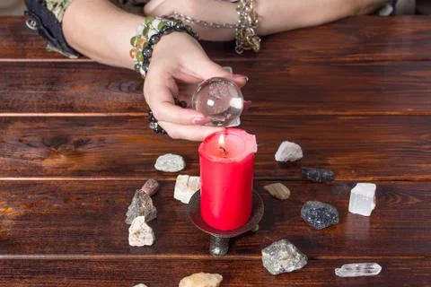 Fortune teller predicts fate using a magic ball, stones and a lit candle.A Gy Foto stock