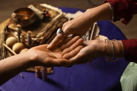 Fortune teller reading man's palm at table, closeup Stock-Fotos