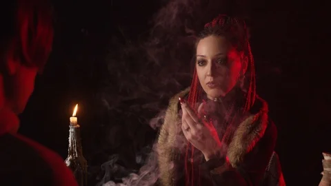 Fortune teller reading palm and predicting future in smoke Stock-Footage 125024662