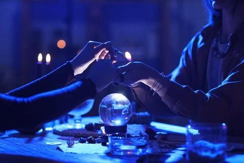 Fortune teller reading woman's palms at table Stock-Fotos