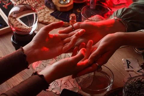 Fortune teller reading woman's palms at table, closeup Stock-Fotos