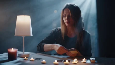 Fortune-Teller at the Table by Candlelight Wonders on Cards Video stock 295313416