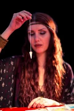 Fortune teller using pendulum with eyes closed Stock Photos