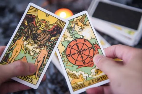 Fortune teller using tarot cards reading future by candlelight on dark backgr Foto stock