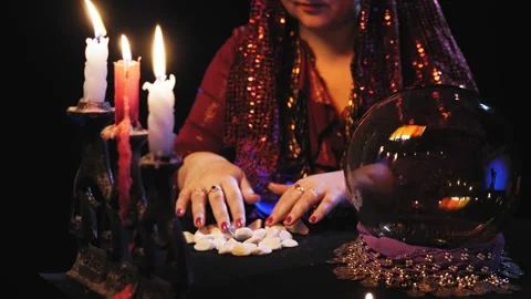 Fortune teller without a face read the future in a crystal ball and white stones Stock Footage 170450387
