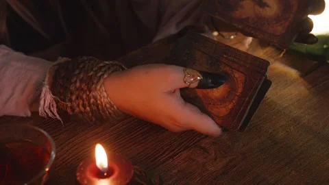 Fortune teller's hands dealing ancient tarot cards on a rustic wooden table, Stock Footage 318869040