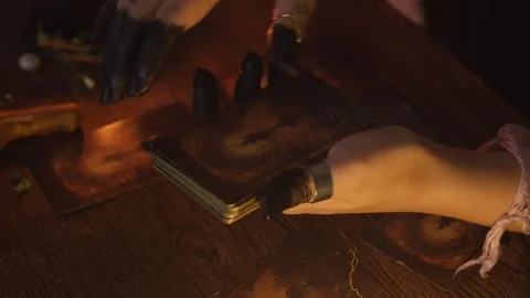 Fortune teller's hands with painted black fingers placing a stack of ornate Stock Footage 318870391