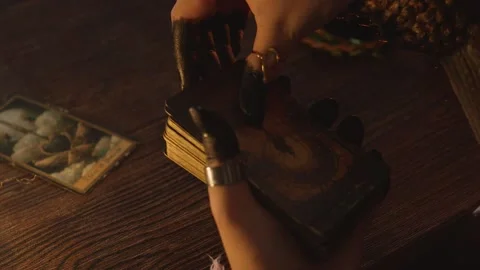Fortune teller's hands performing a tarot card reading, laying out ancient Stock Footage 318869241