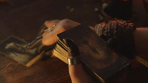 Fortune teller's hands performing a tarot card reading, holding an ornate deck Stock Footage 318869268