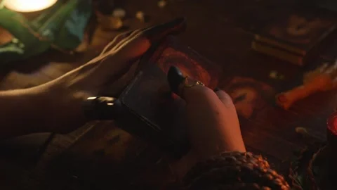 Fortune teller's hands shuffling ancient tarot cards, performing a mysterious Stock Footage 318870348