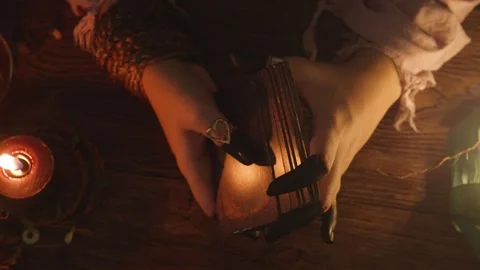 Fortune teller's hands shuffling and presenting ancient tarot cards on a dark Stock Footage 318869135