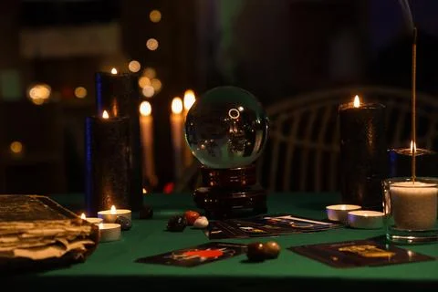 Fortune teller's magic attributes on green table in dark room Stock-Fotos