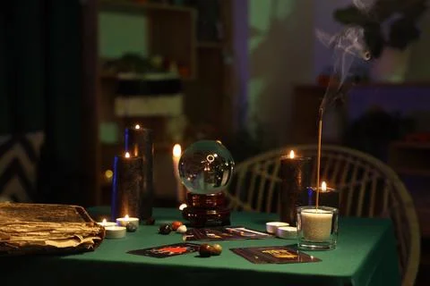 Fortune teller's magic attributes on green table in dark room Stock Photos