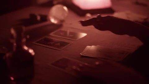 Fortune telling on tarot cards by candlelight, collects cards from the table Stock Footage 305823331