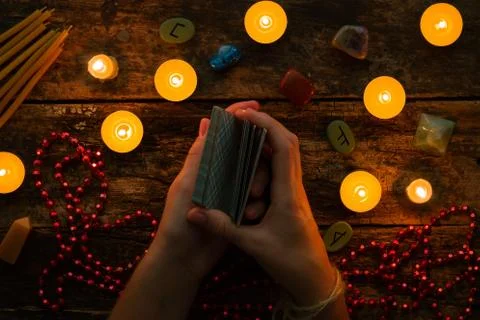 Fortuneteller reads fortunes by tarot cards and candles on the background of  Stock Photos