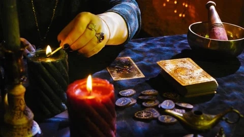 The fortuneteller before the session lights candles on the table where the runes Stock Footage 232525632