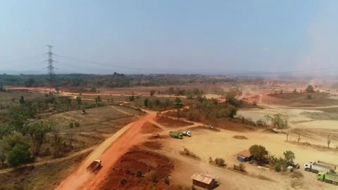 Forward aerial drone shot of construction site road with trucks and power line Stock Footage 346189990