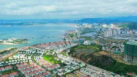 Forward aerial flight tracking coastal residential developments near hills 4K 動画素材 336650882