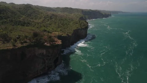 Forward and panning shot of massive steep cliffs along ocean Stock Footage 293714594