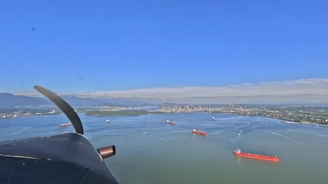 Forward Cockpit view, flying in a propeller airplane towards Stanley Park 库存影片 334816909