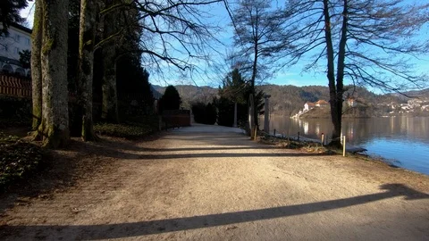 Forward dolly moving on lake Bled shore walkway with island in background Stock Footage 123168658