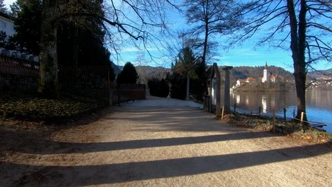 Forward dolly moving on lake Bled shore walkway Stock Footage 123168689