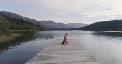 Forward Dolly Shot Of Young Beautiful Woman Practising Yoga At The Lake 스톡 동영상 80096805