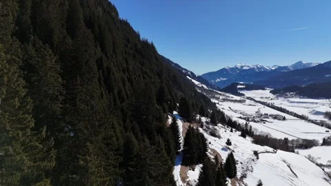 Forward Drone Flight Above Pine Forest Revealing Snowy Alpine Village in Stock Footage 332124325