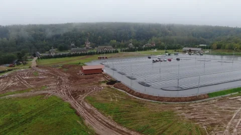 Forward drone flight over field toward wooden complex Vidéo 323974540