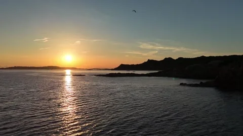 Forward Drone Flight Over Peaceful Sunrise Beach With Sun Behind Hill Vídeo Stock 334946075