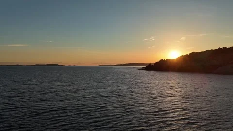 Forward Drone Flight Over Tranquil Beach With Sun Emerging Over Hill 库存影片 334854664