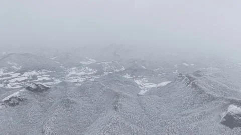 Forward Drone Flight Through Falling Snow Over a White Winter Mountain Landscape Stock Footage 344247752