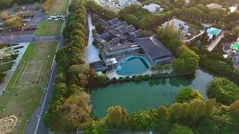 Forward Drone Flight Toward Lakeside Buildings and Swimming Pool 動画素材 341367027