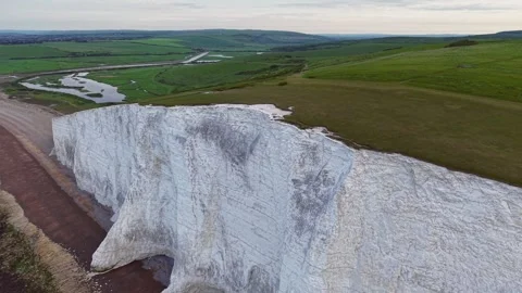 Forward drone flyover along coastal white cliffs revealing scenic valley Stock Footage 309764491