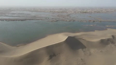 Forward Drone Over Desert Dunes and Lakeshore Ejina Inner Mongolia China Stock Footage 330454996