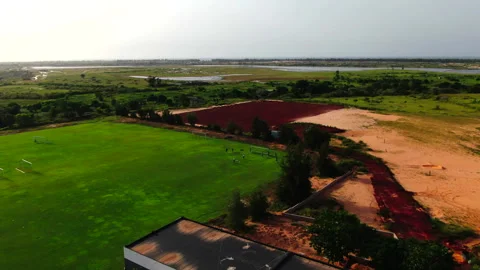 Forward drone over plain with river and left football field, Senegal Stock Footage 331991014