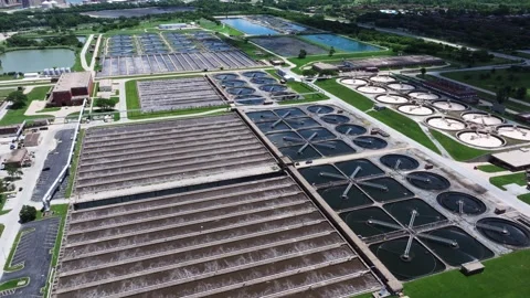 Forward drone shot above a large water reclamation facility revealing circular Stock Footage 338102866
