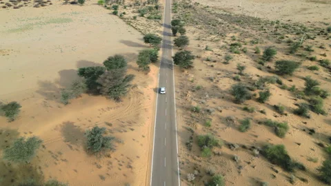 Forward drone shot of car driving on Longewala Road, Jaisalmer, Rajasthan India Stock Footage 297858553