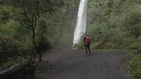 Forward drone shot of a waterfall with the drone pilot visible Stock Footage 249893785