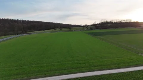 Forward flight above green fields road and moving traffic Stock Footage 331211669