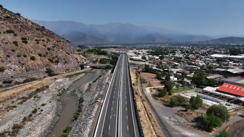 Forward flight along straight highway beside dry Aconcagua river bed at Stock Footage 336267866