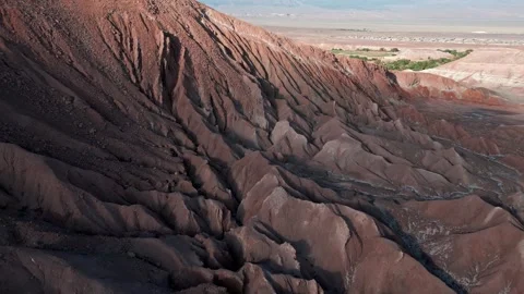 Forward flight hugging dramatic dark eroded salt rock ridge face with deep Stock Footage 336266367