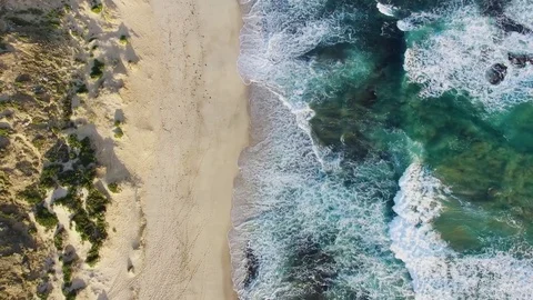 Forward flight looking down at crushing ocean waves tilting the camera upward Stock Footage