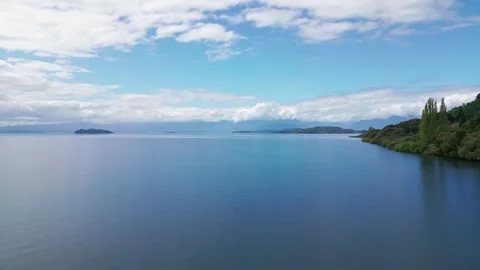 Forward flight over calm lake with islands and forested shore. Lago Ranco, Chile 動画素材 331213109