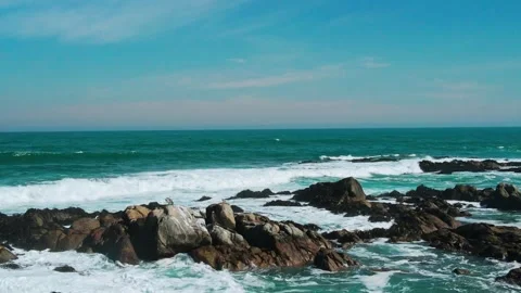 Forward flight over rugged rocky coastline with powerful turquoise waves Видео 332686501