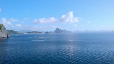 Forward flight over vast open sea toward scattered karst limestone islands Stockbeeldmateriaal 336999475