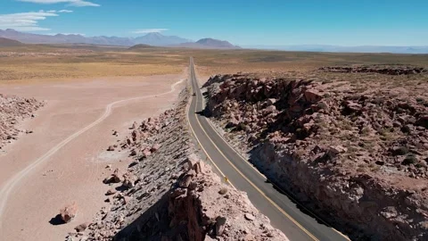 Forward flight over winding paved highway cutting through dramatic red rock Stock Footage 336266209