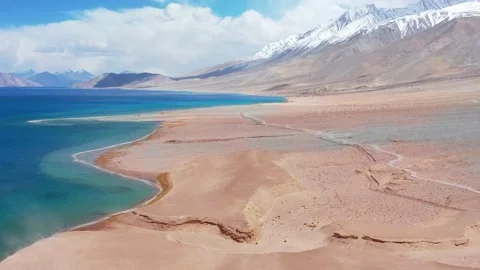 Forward flight tilting up from blue water to snow peaks at Pangong Lake. Stock Footage 336329935