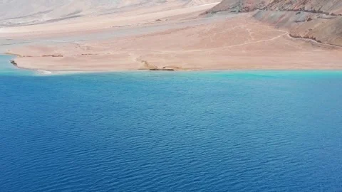 Forward flight tilting up from blue water to snow peaks at Pangong Lake. Stock Footage 336330223